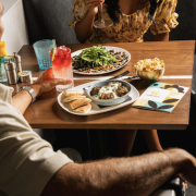Friends enjoying cocktails, small plates, and vibrant atmosphere during Worthwyld Happy Hour in Miami.”